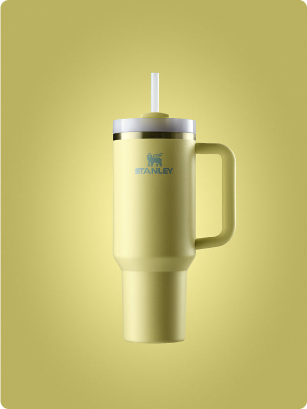 Stanley 1913 quencher tumbler in soft yellow-green with white lid and straw, handle, on matching background.
